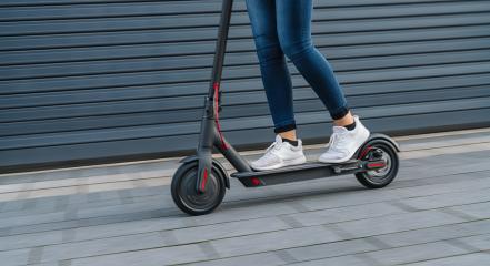 Close up of woman riding black electric kick scooter at cityscape, motion blur- Stock Photo or Stock Video of rcfotostock | RC Photo Stock