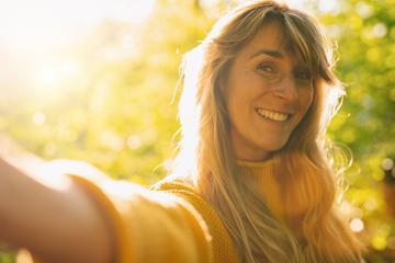 Close up portrait of beautiful woman with long blond hair, taking selfie with smartühone on sunny day in the Nature- Stock Photo or Stock Video of rcfotostock | RC Photo Stock