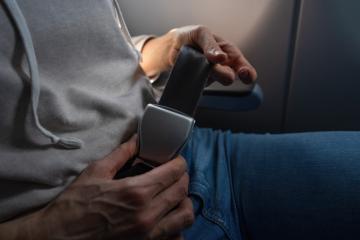 Close-up of a female passenger's hands fastening a seat belt on a plane. safe flight on airplane concept image- Stock Photo or Stock Video of rcfotostock | RC Photo Stock