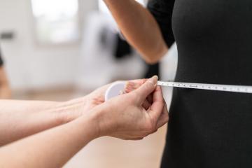 Close-up of a fitness trainer measuring a woman's waist with a tape measure in a gym. Fitness and health concept image- Stock Photo or Stock Video of rcfotostock | RC Photo Stock