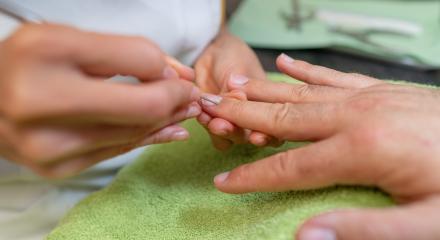 Close-up of a manicure with a pusher removes calluses from a client's fingernail. body care spa treatment concept image- Stock Photo or Stock Video of rcfotostock | RC Photo Stock