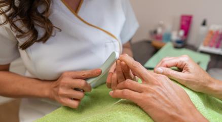 Close-up of a manicurist buffing a client's nails with a nail buffer in a beauty salon. body care spa treatment concept image- Stock Photo or Stock Video of rcfotostock | RC Photo Stock