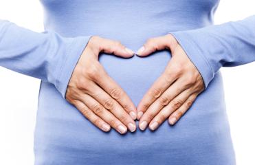 Close-up of a woman in a blue shirt forming a heart shape with her hands on her belly, symbolizing love, care, pregnancy, and motherhood : Stock Photo or Stock Video Download rcfotostock photos, images and assets rcfotostock | RC Photo Stock.: