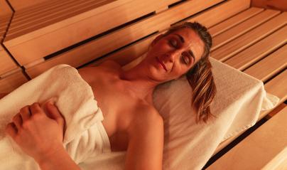 Close-up of a woman relaxing in a Finnish sauna at a hotel, warm tones, wooden backdrop. Spa and Wellness concept image- Stock Photo or Stock Video of rcfotostock | RC Photo Stock