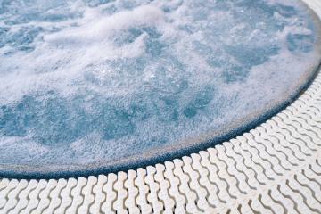 Close-up of bubbling water in a jacuzzi with a textured edge, showcasing a serene spa setting- Stock Photo or Stock Video of rcfotostock | RC Photo Stock