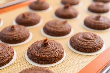 Close-up of freshly piped gingerbread dough on wafers, arranged on a silicone baking mat, ready for baking in the oven. The texture and shape of the gingerbread dough are clearly visible- Stock Photo or Stock Video of rcfotostock | RC Photo Stock