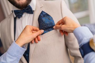 Close-up of tailor placing a blue patterned pocket square in a suit jacket- Stock Photo or Stock Video of rcfotostock | RC Photo Stock