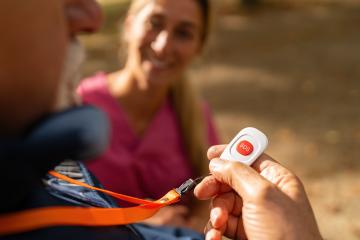 Close-up view of a caregiver's hand holding an SOS button offered to an elderly man, focused on safety and assistance : Stock Photo or Stock Video Download rcfotostock photos, images and assets rcfotostock | RC Photo Stock.: