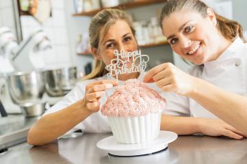 confectioners smiling proudly and decorating big Birthday cake muffin with candies at pastry bakery : Stock Photo or Stock Video Download rcfotostock photos, images and assets rcfotostock | RC Photo Stock.:
