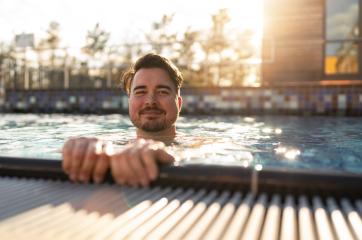 Content man leaning on the edge of a pool in a hotel, sunlight s- Stock Photo or Stock Video of rcfotostock | RC Photo Stock
