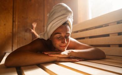 Contented woman lying on a finnish sauna bench with a towel wrapped around her head. Spa wellness hotel concept image.- Stock Photo or Stock Video of rcfotostock | RC Photo Stock