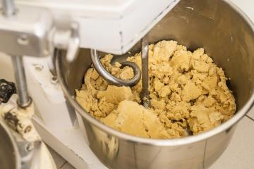 Cookie dough being mixed in an industrial mixer in a bakery, with a dough hook attachment, preparing the dough for baking in a professional baking environment : Stock Photo or Stock Video Download rcfotostock photos, images and assets rcfotostock | RC Photo Stock.: