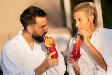 couple in white bathrobes drinking cocktails and looking at each other at a hotel- Stock Photo or Stock Video of rcfotostock | RC Photo Stock