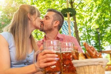 Couple kissing and clinking glasses with mug of beer in Bavarian beer garden or oktoberfest : Stock Photo or Stock Video Download rcfotostock photos, images and assets rcfotostock | RC Photo Stock.: