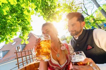 Couple sitting in Beer garden or oktoberfest at summer and enjoy a glass of beer and the sun- Stock Photo or Stock Video of rcfotostock | RC Photo Stock