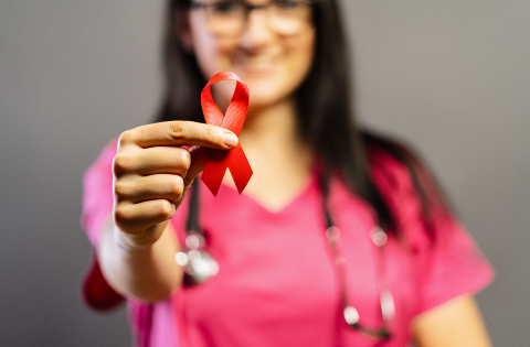 Doctor holds red badge ribbon in hands to support AIDS Day. Healthcare, medicine and AIDS awareness concept.- Stock Photo or Stock Video of rcfotostock | RC Photo Stock