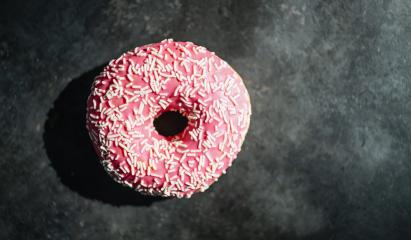donut with pink glazed and sprinkles on a dark table- Stock Photo or Stock Video of rcfotostock | RC-Photo-Stock