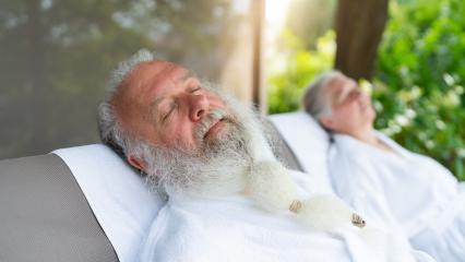 Elderly couple relaxing in white bathrobes on outdoor loungers in a spa wellness hotel- Stock Photo or Stock Video of rcfotostock | RC Photo Stock