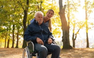 Elderly man in a wheel chair and a nurse enjoying a sunny day in the park, both smiling and looking happy- Stock Photo or Stock Video of rcfotostock | RC Photo Stock