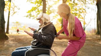 Elderly man in astronaut helmet and nurse in pink uniform laugh joyfully, with the man gesturing expansively in a park. Dementia retirement home concept image : Stock Photo or Stock Video Download rcfotostock photos, images and assets rcfotostock | RC Photo Stock.: