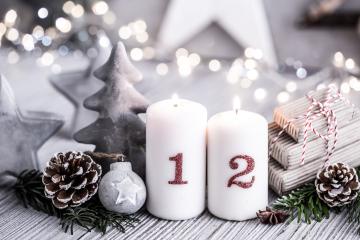 Elegant Christmas arrangement with two numbered candles, pinecones, fir branches, a small ornament, and wrapped gifts, set on a wooden surface with soft fairy lights in the background : Stock Photo or Stock Video Download rcfotostock photos, images and assets rcfotostock | RC Photo Stock.: