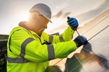 engineer using a screwdriver to  assembling a solar panel in a solar park at sunset. Alternative energy ecological concept image.- Stock Photo or Stock Video of rcfotostock | RC Photo Stock