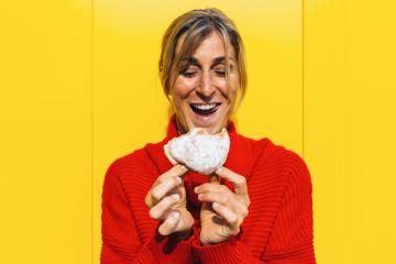 Enthusiastic woman bite into a strawberry jam filled berliner doughnut against yellow wall : Stock Photo or Stock Video Download rcfotostock photos, images and assets rcfotostock | RC Photo Stock.: