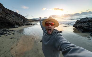 Excited man in straw hat and sunglasses taking a selfie on a sandy beach at sunset and enjoying summer holidays - Stock Photo or Stock Video of rcfotostock | RC Photo Stock