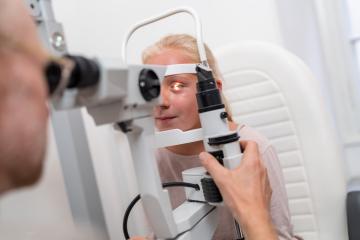 Eye examination with young patient looking into an optometry machine or tonometer at eye clinic- Stock Photo or Stock Video of rcfotostock | RC Photo Stock