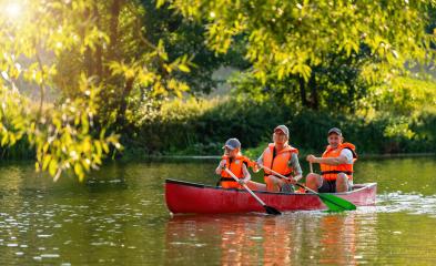 Family of three canoeing on a river, framed by overhanging green branches in golden evening sunlight in bavaria, germany. Family on kayak ride. Wild nature and water fun on summer Vacation.- Stock Photo or Stock Video of rcfotostock | RC Photo Stock