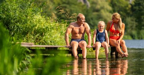 Family sitting on a wooden dock by a lake, dangling their feet in the water, surrounded by lush greenery in bavaria germany : Stock Photo or Stock Video Download rcfotostock photos, images and assets rcfotostock | RC Photo Stock.: