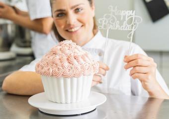 female confectioner decorating big Birthday cake muffin with candies at pastry bakery : Stock Photo or Stock Video Download rcfotostock photos, images and assets rcfotostock | RC Photo Stock.: