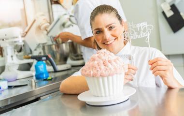 female confectioner smiling proudly and decorating big Birthday cake muffin with candies at pastry bakery : Stock Photo or Stock Video Download rcfotostock photos, images and assets rcfotostock | RC Photo Stock.: