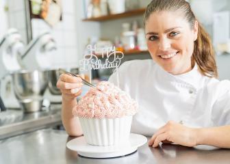 female confectioner smiling proudly and decorating big Birthday cake muffin at pastry bakery : Stock Photo or Stock Video Download rcfotostock photos, images and assets rcfotostock | RC Photo Stock.: