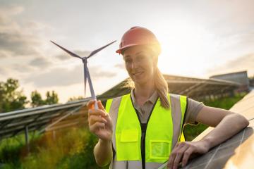 Female engineer with wind turbine model at solar energy farm photovoltaic panel system at sunset. Alternative energy ecological concept.- Stock Photo or Stock Video of rcfotostock | RC Photo Stock