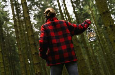 Female Hiker holding a oil lantern or kerosene lamp and walking in the dark forest- Stock Photo or Stock Video of rcfotostock | RC Photo Stock
