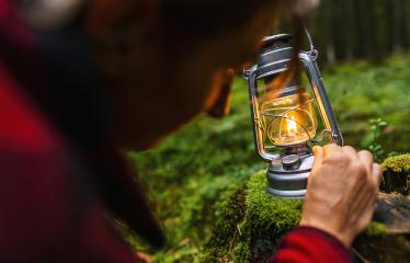 Female Hiker using a kerosene lamp or oil lantern in the dark forest- Stock Photo or Stock Video of rcfotostock | RC Photo Stock