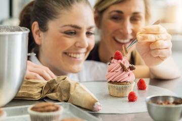 female team of confectioners draped pieces of chocolate on a muffin topping with tweezers in a pastry bakery : Stock Photo or Stock Video Download rcfotostock photos, images and assets rcfotostock | RC Photo Stock.: