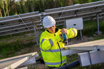 Female technician using a cordless drill on solar panel structure in a field. Alternative energy ecological concept image.- Stock Photo or Stock Video of rcfotostock | RC Photo Stock