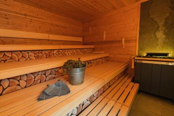 finnish sauna interior with stacked wood, benches, a sauna bucket, vihta (birch whisks), and felt hats : Stock Photo or Stock Video Download rcfotostock photos, images and assets rcfotostock | RC Photo Stock.: