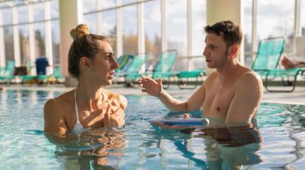 Focused conversation between a male trainer and female client during a pool rehabilitation session- Stock Photo or Stock Video of rcfotostock | RC Photo Stock