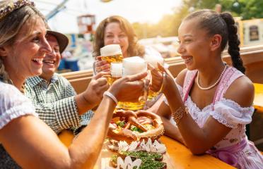 Four friends in beer tent at Dult or Oktoberfest toasting with beer mugs up in the air- Stock Photo or Stock Video of rcfotostock | RC Photo Stock