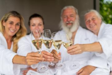 four people in white bathrobes toasting with champagne glasses and celebrating a spa wellness day in a hotel- Stock Photo or Stock Video of rcfotostock | RC Photo Stock