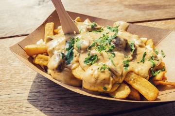 french fries with mushrooms sauce and cheese in a paper bowl with on a wooden table- Stock Photo or Stock Video of rcfotostock | RC Photo Stock