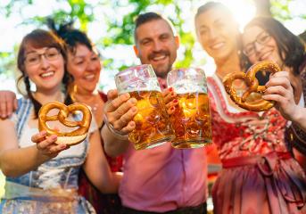 friends in Tracht, Dirndl and Lederhosen having fun drinking beer and eating pretzels in Beer garden or oktoberfest in Bavaria, Germany- Stock Photo or Stock Video of rcfotostock | RC Photo Stock