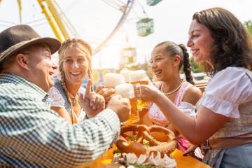 friends in Tracht, Dirndl and Lederhosen sitting in beer tend in front of a Ferris wheel at Oktoberfest or Dult in germany- Stock Photo or Stock Video of rcfotostock | RC Photo Stock