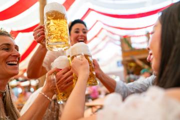 Friends toasting with beer in an Oktoberfest beer tent, celebrating with traditional Bavarian attire, and enjoying a fun festival atmosphere : Stock Photo or Stock Video Download rcfotostock photos, images and assets rcfotostock | RC Photo Stock.: