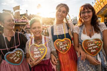 Friends visiting together Bavarian oktoberfest in Dirndl with Schenk mir dein Herz, Für mein Schatz, Ich hab dich lieb (German: Give me your heart, For my sweetheart) written on gingerbreads heart : Stock Photo or Stock Video Download rcfotostock photos, images and assets rcfotostock | RC Photo Stock.: