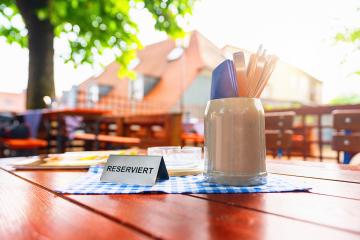 german beer garden table with reserved table sign with places setting at summer- Stock Photo or Stock Video of rcfotostock | RC Photo Stock