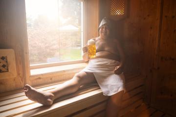 German man in a finnish sauna wearing a felt hat, holding a beer mug, smiling with a window behind. - Stock Photo or Stock Video of rcfotostock | RC Photo Stock